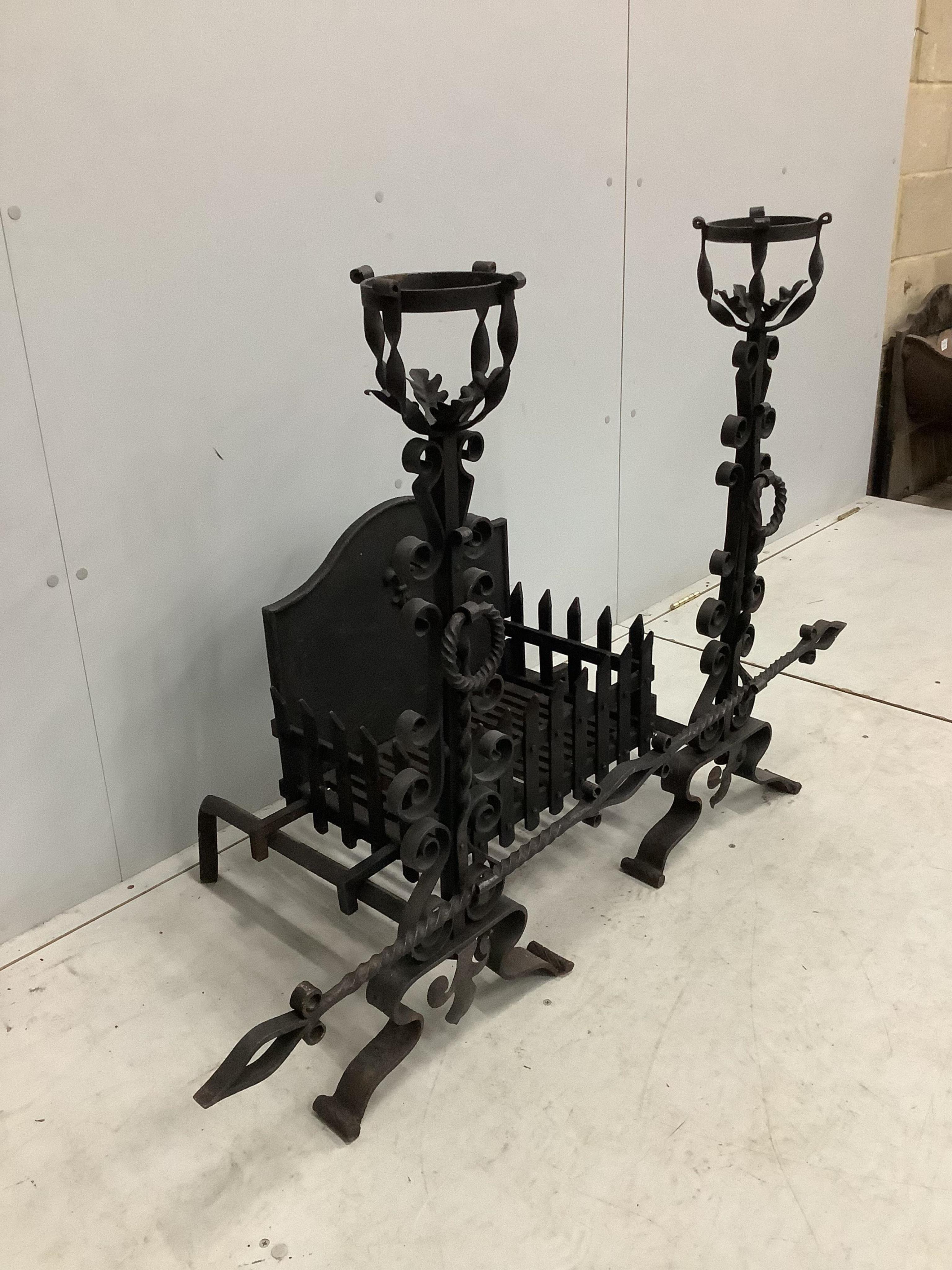 A French wrought iron fire basket with dogs and cast fire back, width 127cm, depth 53cm, height 88cm. Condition - good